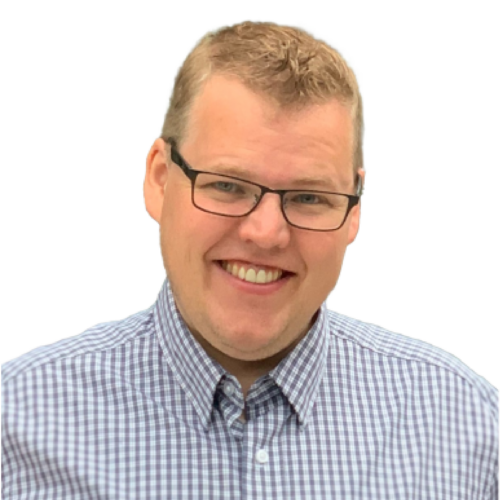 Headshot of a grinning man wearing glasses and a plaid shirt.